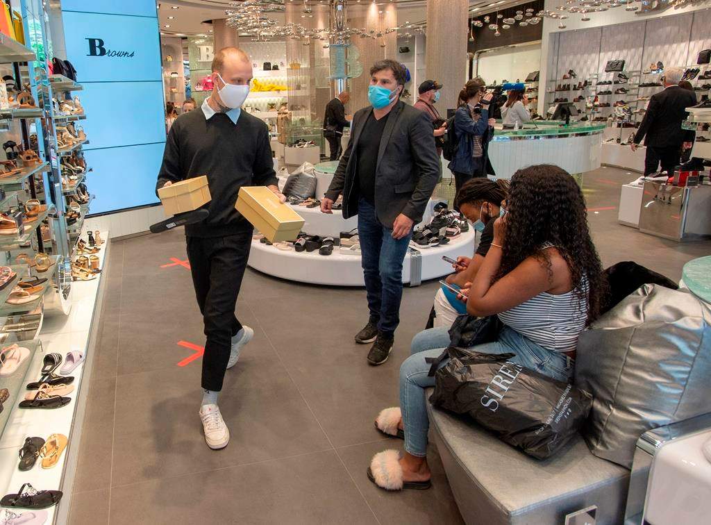 Customers shop for shoes at Brown's shoe store as many non-essential businesses are allowed to reopen Monday, May 25, 2020 in Montreal.
