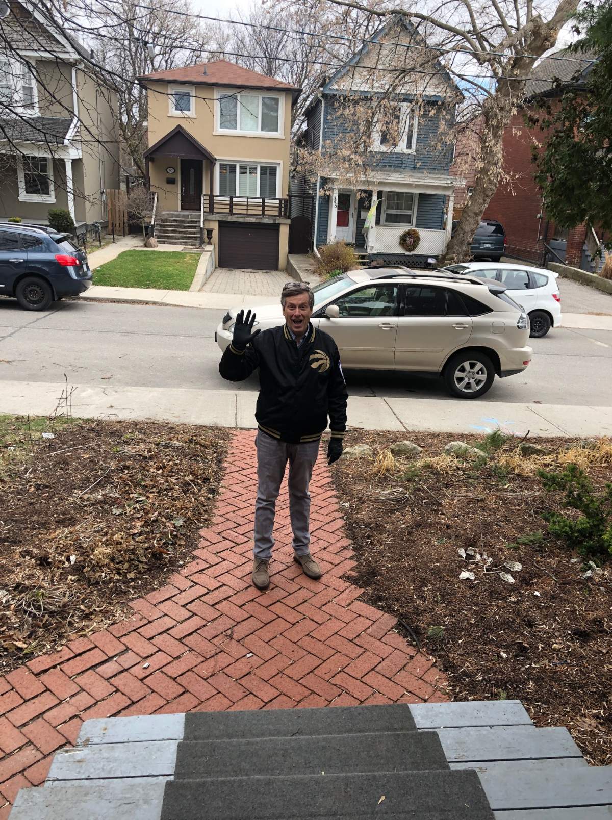 Toronto Mayor John Tory practices ‘social distancing’ by standing outside his daughter’s home to deliver treats for his granddaughters.