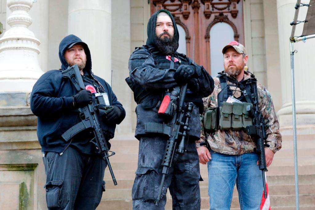Armed protesters provide security as demonstrators take part in an “American Patriot Rally,” organized on April 30, 2020, by Michigan United for Liberty on the steps of the Michigan State Capitol in Lansing, demanding the reopening of businesses.