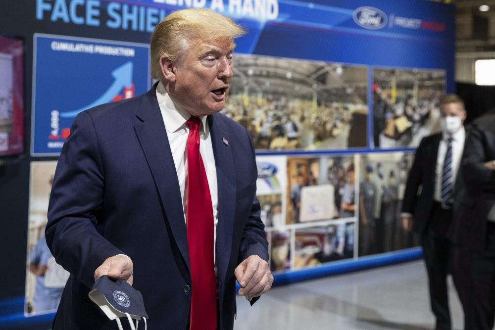 U.S. President Donald Trump holds his protective face mask as he speaks while touring Ford’s Rawsonville components plant that has been converted to make personal protective and medical equipment, Thursday, May 21, 2020, in Ypsilanti, Mich.