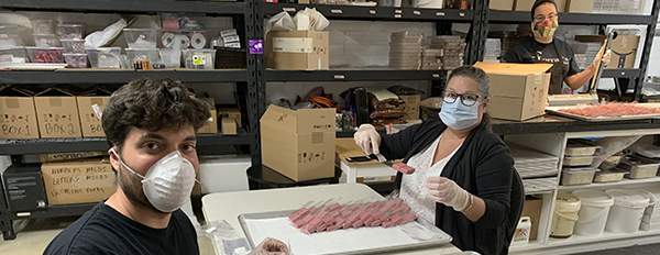 Volunteers Rita Parent, David Santos and Antonio Santos packaging raspberry velvet chocolates.