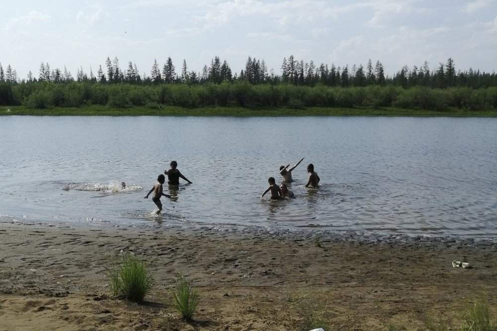 In this handout photo provided by Olga Burtseva, children play in the Krugloe lake outside Verkhoyansk, the Sakha Republic, about 4660 kilometers northeast of Moscow, Russia, Sunday, June 21, 2020. A Siberian town that endures the world's widest temperature range has recorded a new high amid a hear wave that is contributing to severe forest fires. Russia's meteorological service said the thermometer hit 38 Celsius on Saturday in Verkhoyansk, in the Sakha Republic about 4660 kilometers northeast of Moscow.