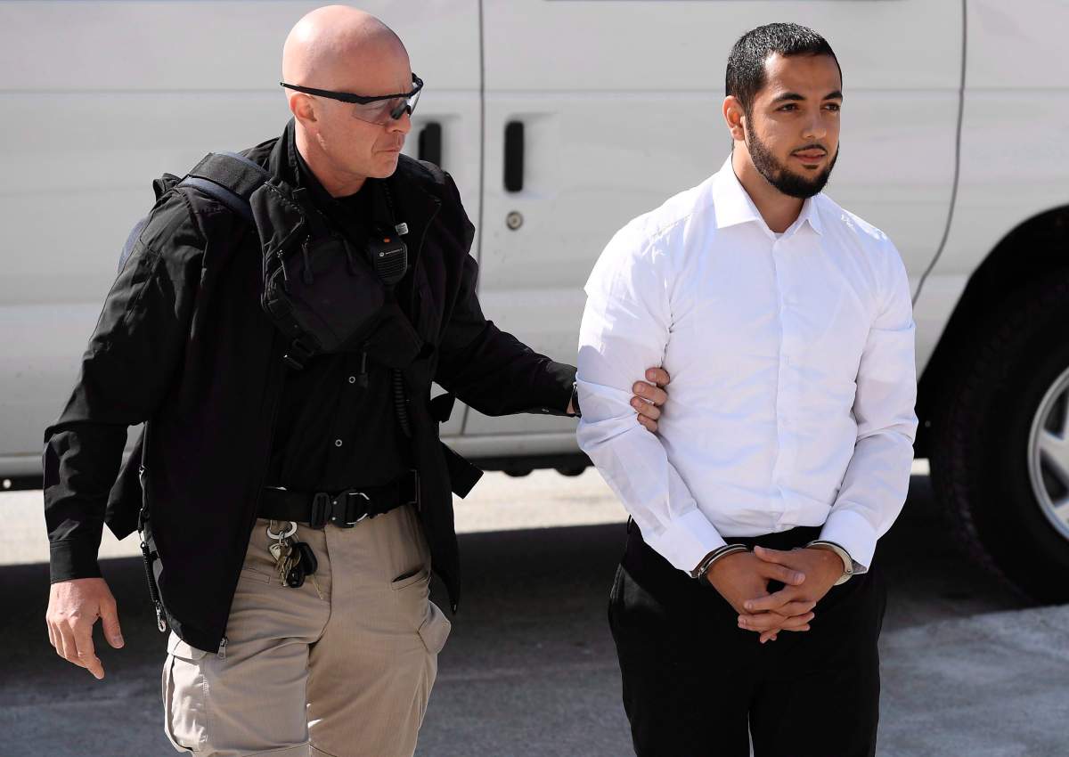 Awso Peshdary, who is accused of recruiting for ISIL, is escorted by police as he arrives for a hearing at the Supreme Court of Canada in Ottawa on Monday, Aug. 13, 2018. 