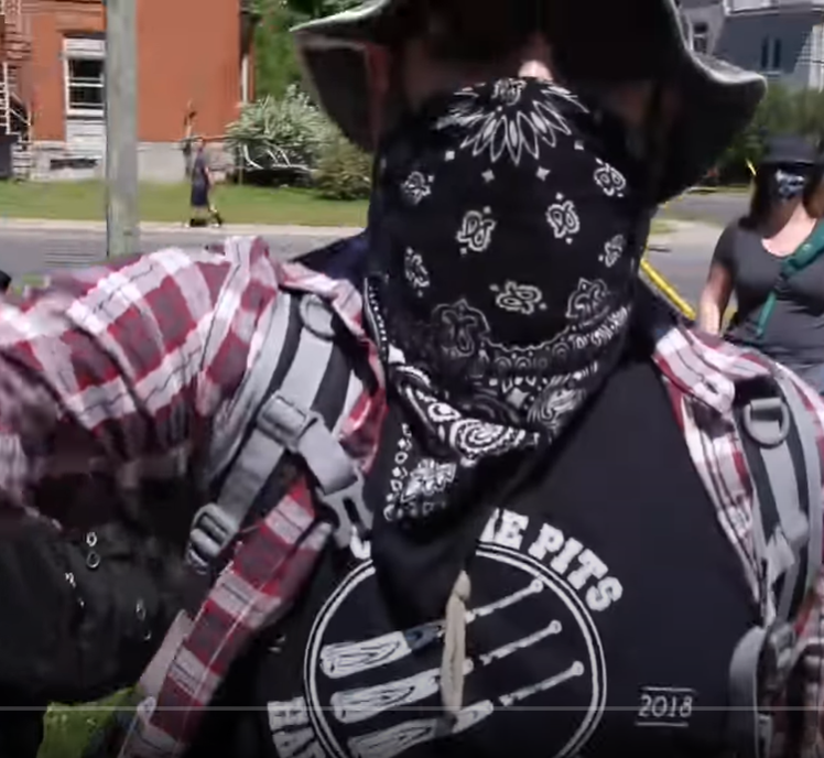 Kingston police have charged this man after he allegedly shoved a media personality at a protest on June 20.