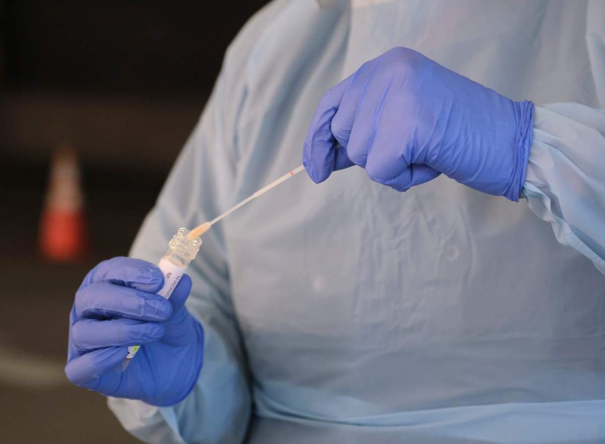 A nurse collects a specimen at a novel coronavirus drive-thru testing station in Seattle, Wash., March 16, 2020. 