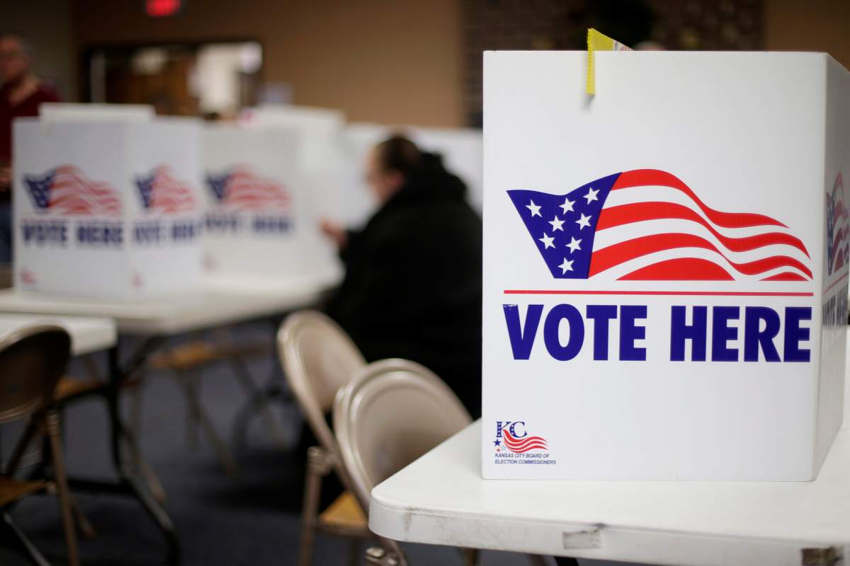 In this March 10, 2020 file photo, a woman votes in the presidential primary election at the the Summit View Church of the Nazarene in Kansas City, Mo.