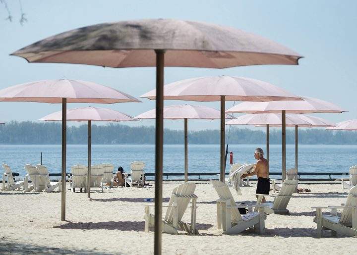 People practice physical distancing as they enjoy the hot weather at Sugar Beach during the COVID-19 pandemic in Toronto on Tuesday, May 26, 2020. 