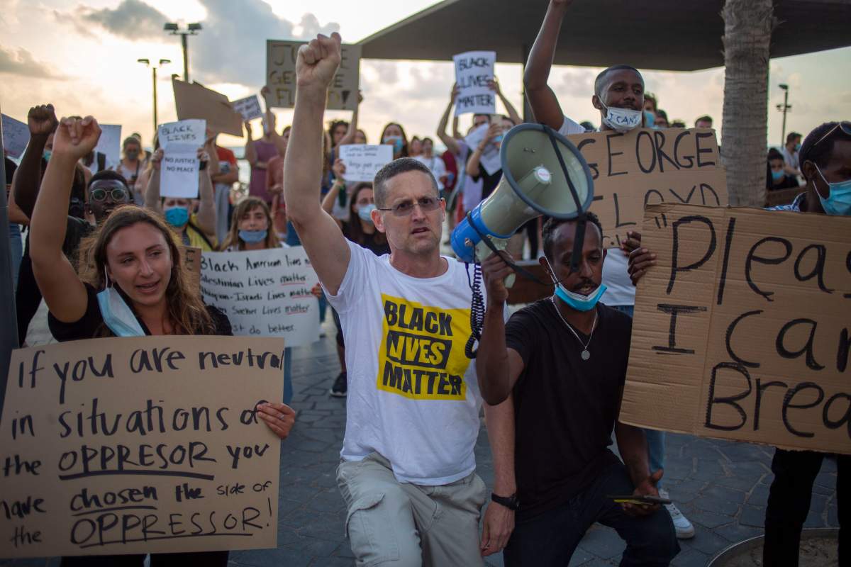 Protesters hold signs and shout slogans during a protest to decry the killing of George Floyd in front of the American embassy in Tel Aviv, Israel, June 2, 2020.