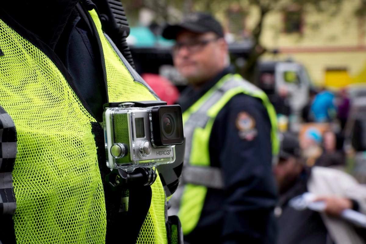 The mayor of Iqaluit is joining other Arctic leaders in a call to have RCMP members in Nunavut wear body cameras. A member of the Vancouver Police Department wears a chest mounted camera as he oversees the take down of a tent city in downtown Vancouver on Oct. 16, 2014.
