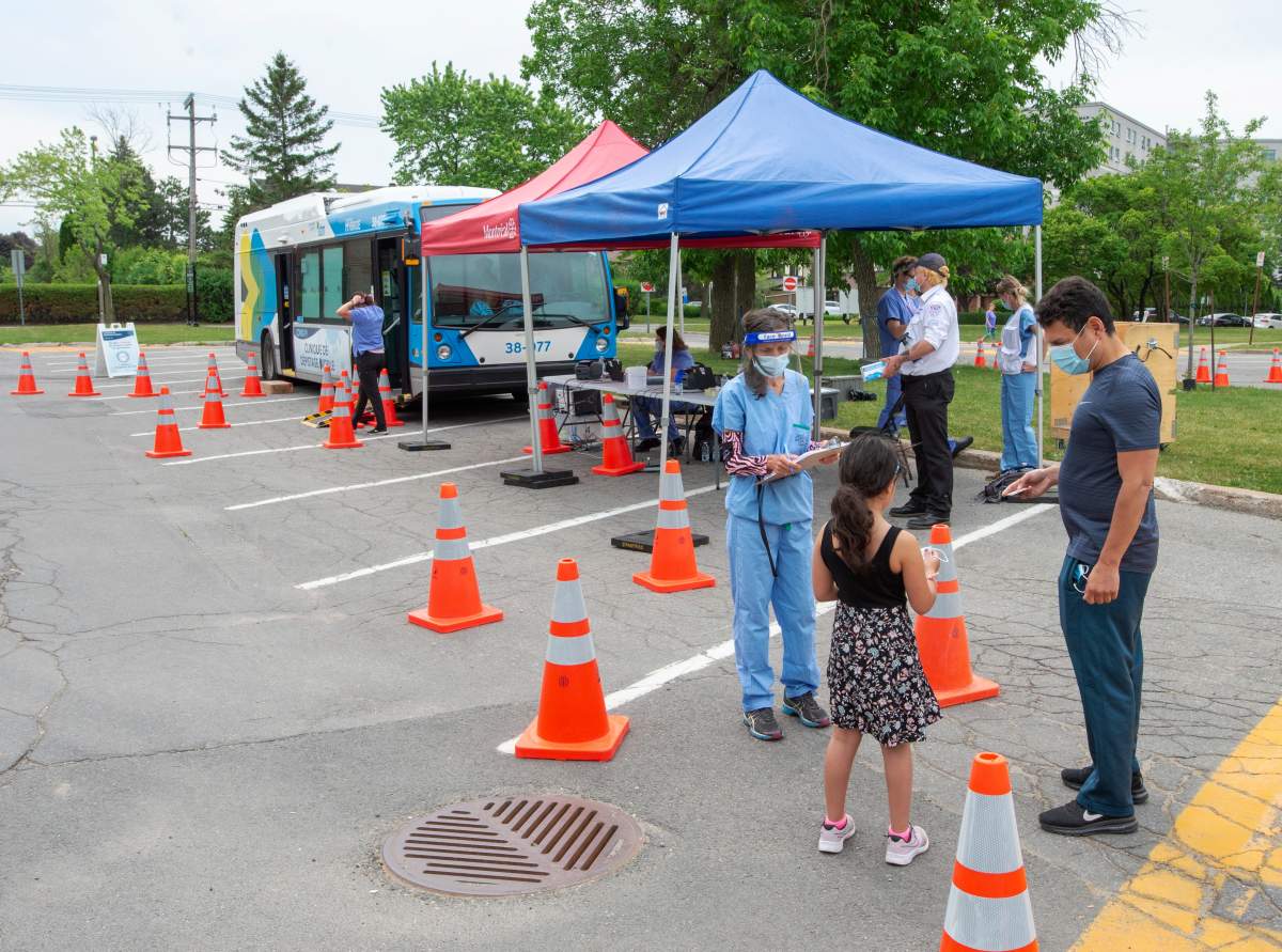 A man and his child are among the few people at a mobile COVID-19 testing clinic in Montreal, Wednesday, June 10, 2020. 