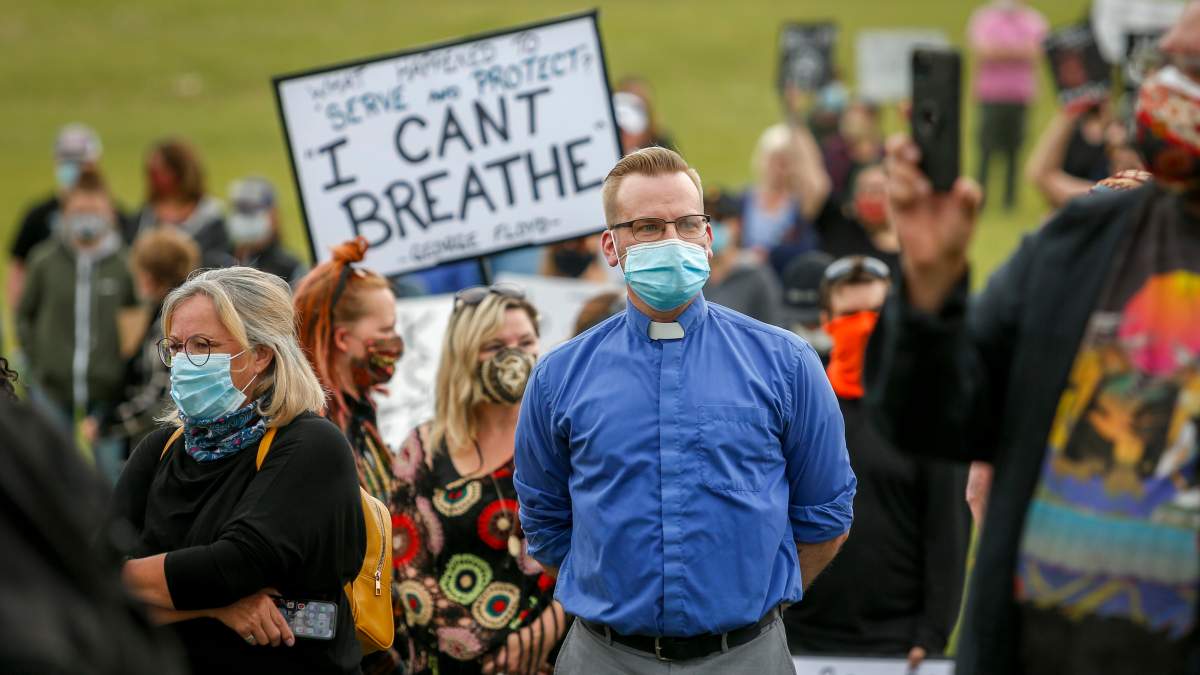 A member of the clergy attends a Black Lives Matter protest in Innisfail, Alta., Saturday, June 13, 2020, amid the COVID-19 pandemic.