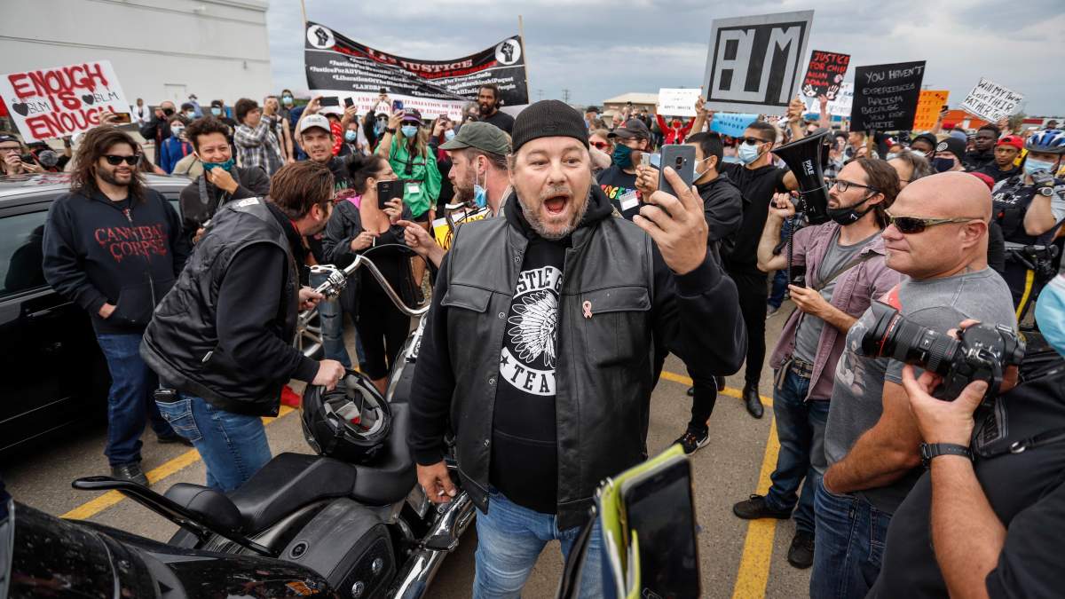 Black Lives Matter protesters are confronted by an opponent, centre, of the protest in Innisfail, Alta., Saturday, June 13, 2020, amid the COVID-19 pandemic.