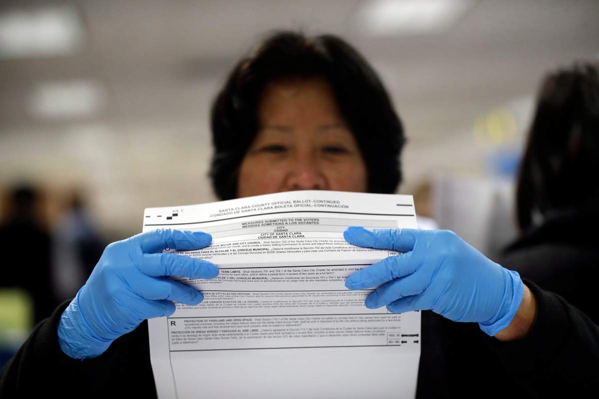 FILE - In this Nov. 4, 2016, file photo, a mail-in ballot is examined at the Santa Clara County Registrar of Voters in San Jose, Calif.
