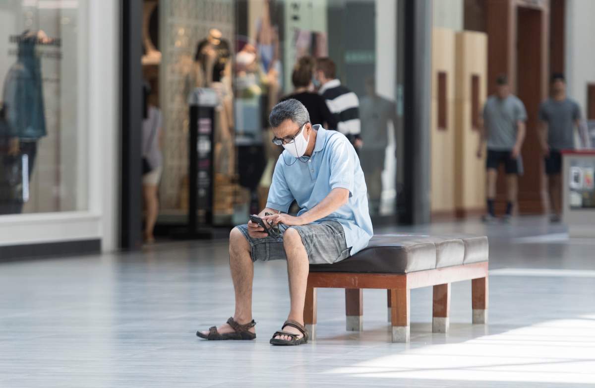 A man sits inside an open shopping mall in Montreal, Saturday, June 20, 2020, as the COVID-19 pandemic continues in Canada and around the world. THE CANADIAN PRESS/Graham Hughes.