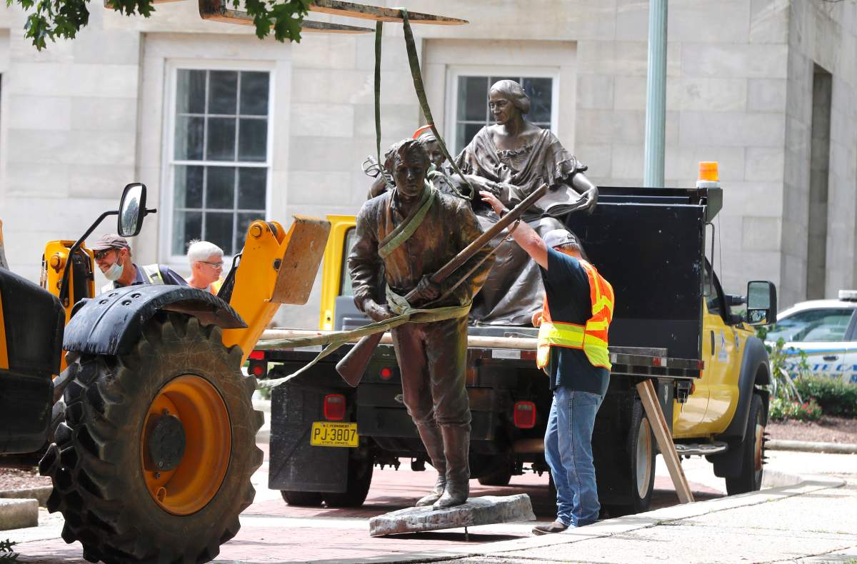 Crews add The Henry Wyatt Monument to a truck after removing them from the North Carolina State Capitol in Raleigh, N.C., June 20, 2020.