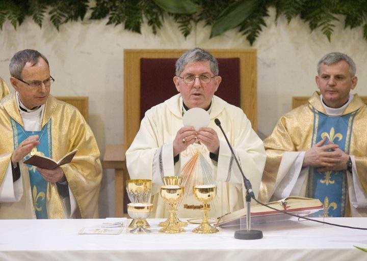 Thomas Christopher Collins (centre), the Archbishop of Toronto, leads communion at a service at St. Casimir's  Catholic Church in this file photo.