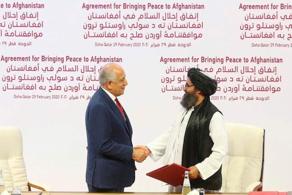 FILE - In this Feb. 29, 2020 file photo, U.S. peace envoy Zalmay Khalilzad, left, and Mullah Abdul Ghani Baradar, the Taliban group's top political leader shake hands after signing a peace agreement between Taliban and U.S. officials in Doha, Qatar.