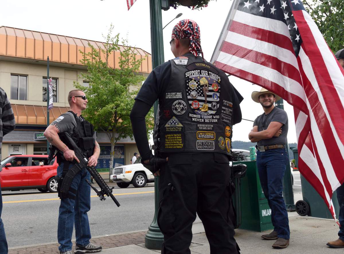 Armed men stand nearby during a Black Lives Matter protest in Coeur d'Alene, Idaho, on June 2, 2020.