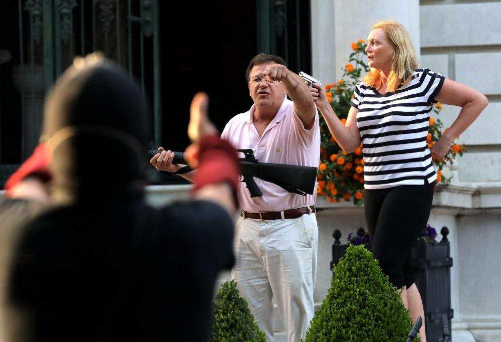 Armed homeowners standing in front their house along Portland Place confront protesters marching to St. Louis Mayor Lyda Krewson’s house Sunday, June 28, 2020, in the central west end of St. Louis, Mo.