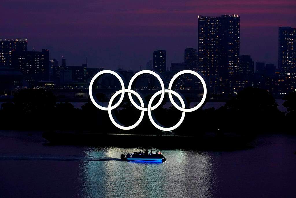 FILE - In this June 3, 2020, photo, the Olympic rings float in the water at sunset in the Odaiba section in Tokyo.