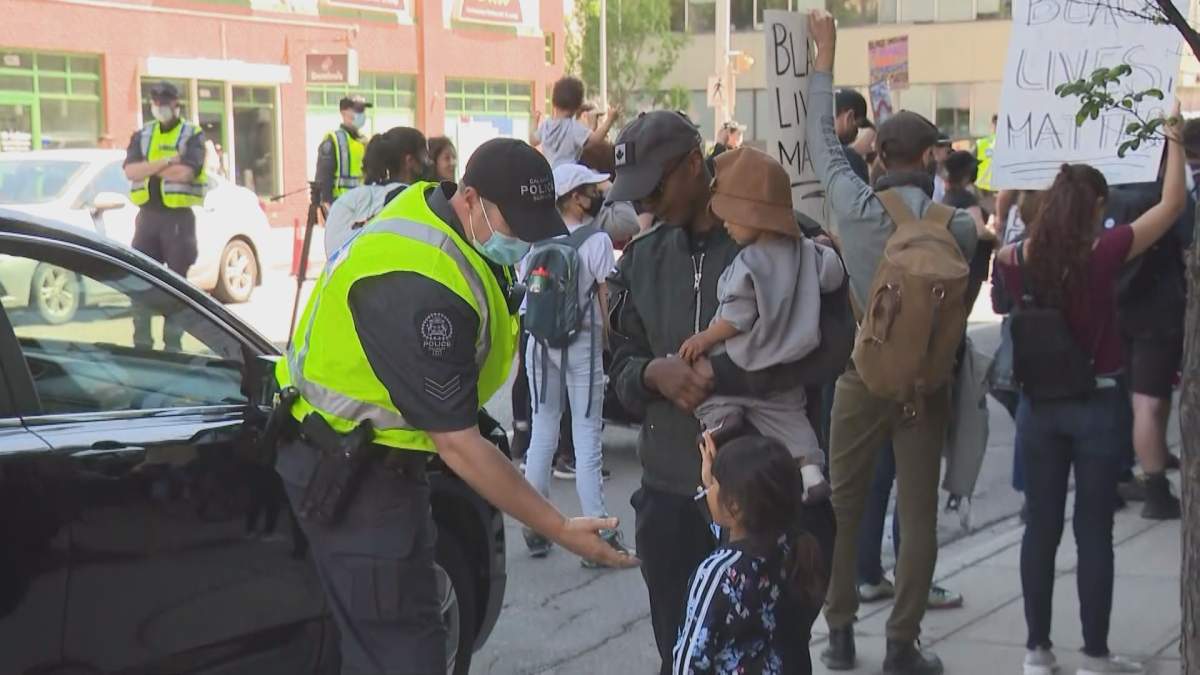 A Calgary police officer gives a low-five to a young girl at an anti-racism rally in Calgary.