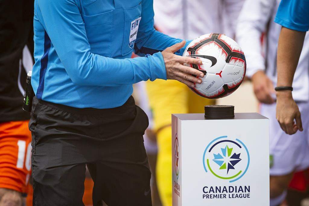 A referee takes the game ball from a pedestal at the beginning of the inaugural soccer match of the Canadian Premier League between Forge FC of Hamilton and York 9 in Hamilton, Ont. Saturday, April 27, 2019. THE CANADIAN PRESS/Aaron Lynett.