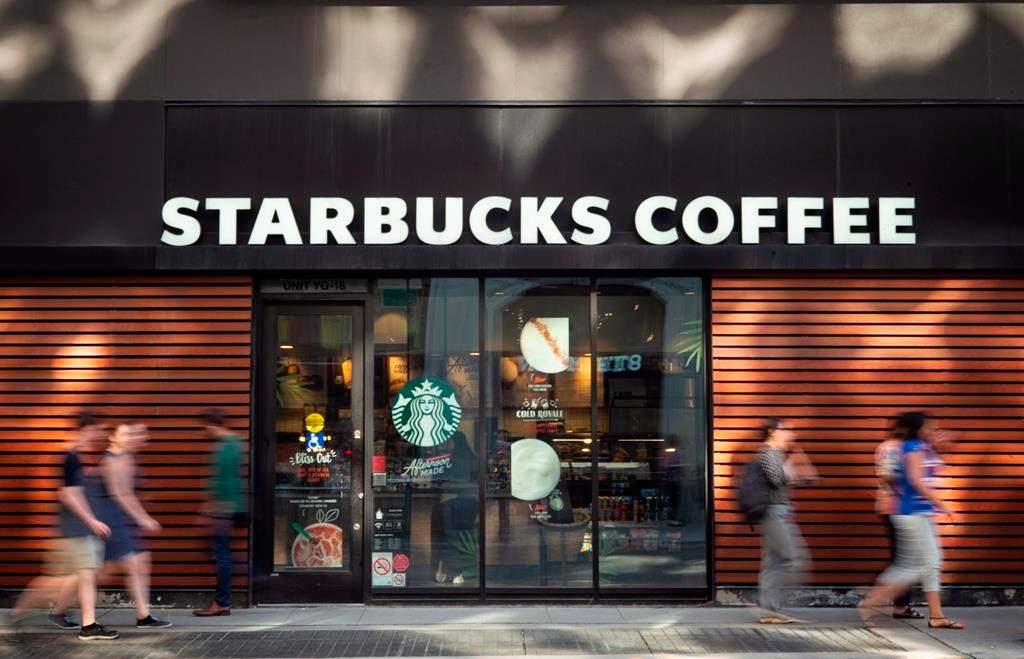 Pedestrians walk past a downtown Toronto Starbucks Coffee location Thursday, May 31, 2018.
