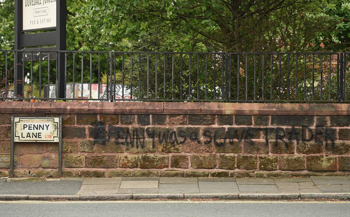 Graffiti reading “Penny was a slave trader” is pictured on a wall on Penny Lane in Liverpool, England, on June 12, 2020.
