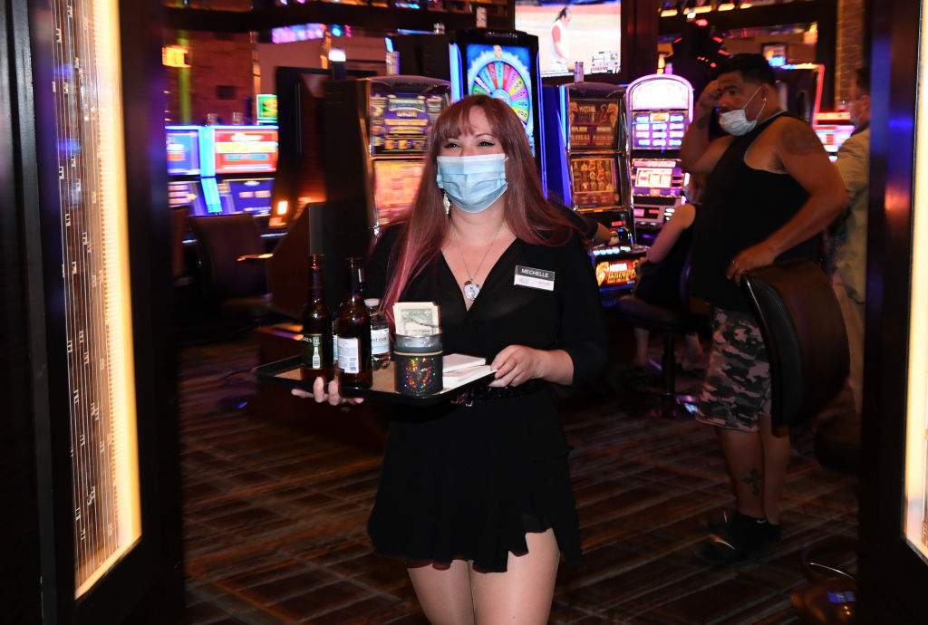 Mechelle McIntyre wears a mask as she carries drinks to guests at the Red Rock Resort after the property opened for the first time since being closed on March 17 because of the coronavirus (COVID-19) pandemic on June 4, 2020 in Las Vegas, Nevada.