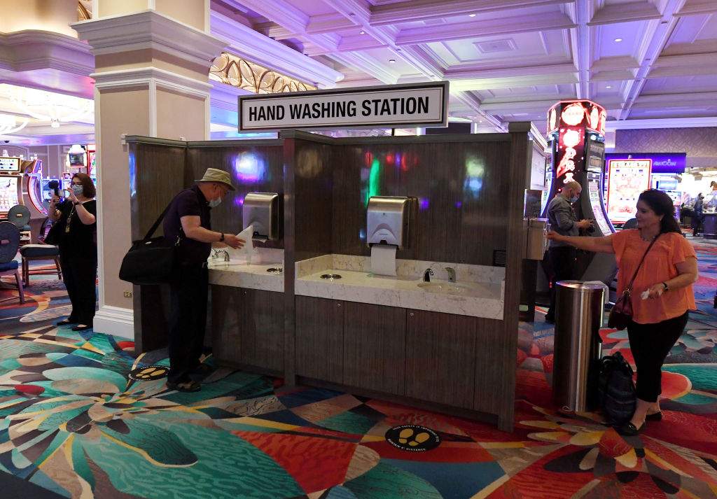 Guests use a new hand-washing station with mask and glove dispensers set up on the gaming floor at Bellagio Resort & Casino on the Las Vegas Strip after the property opened for the first time since being closed on March 17 because of the coronavirus (COVID-19) pandemic on June 4, 2020 in Las Vegas, Nevada.
