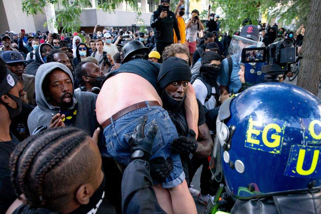 Patrick Hutchinson helped an injured man away after he was allegedly attacked by some of the crowd of protesters as police try to intervene on the Southbank near Waterloo station on June 13, 2020 in London, United Kingdom.