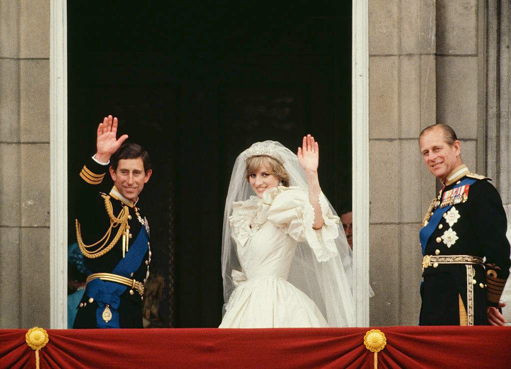 Princess Diana and Prince Charles wave from the Buckingham Palace balcony on their wedding day, sided by Prince Philip.