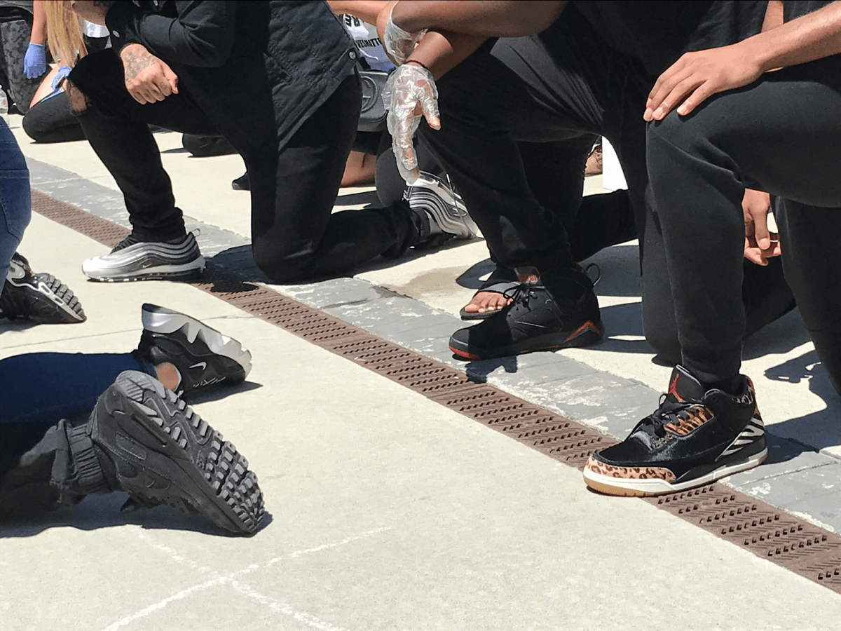 Protesters kneeling during a rally against police violence in downtown Hamilton.