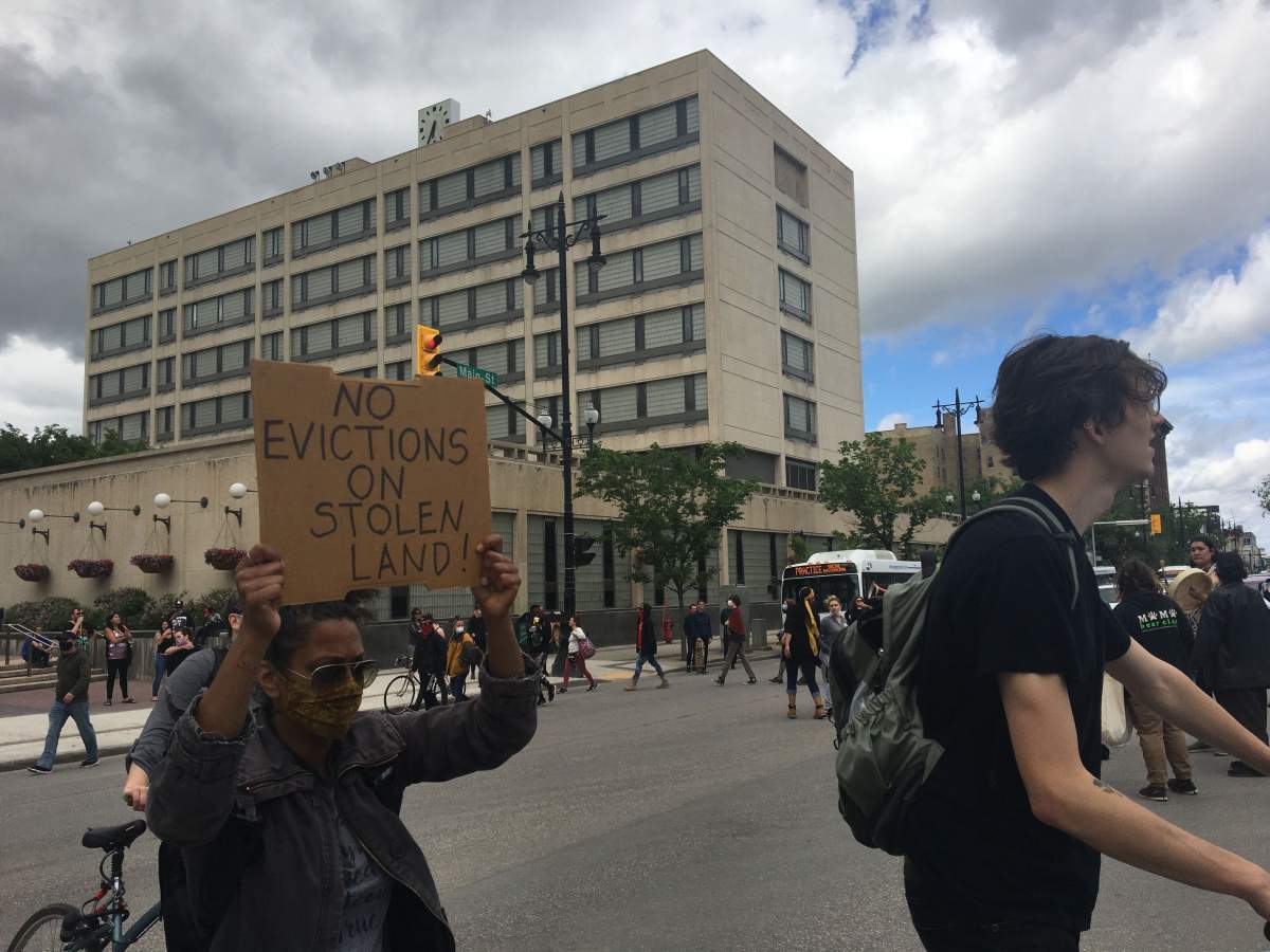 Demonstrators block traffic on Main Street in front of Winnipeg City Hall.