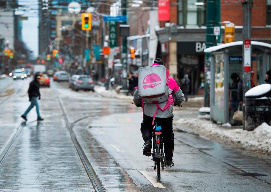 A Foodora courier is pictured as they pick up an order for delivery from a restaurant in Toronto on February 27, 2020. An overwhelming majority of Foodora couriers in Toronto and Mississauga voted in favour of unionizing months before the delivery app exited Canada. The Canadian Union of Postal Workers says 88.8 per cent of the couriers in the area threw their support behind unionization. The union is sharing the number because the Ontario Labour Relations Board recently unsealed and counted ballots nine months after a certification vote asked couriers last August if they wanted to unionized with CUPW. THE CANADIAN PRESS/Nathan Denette.