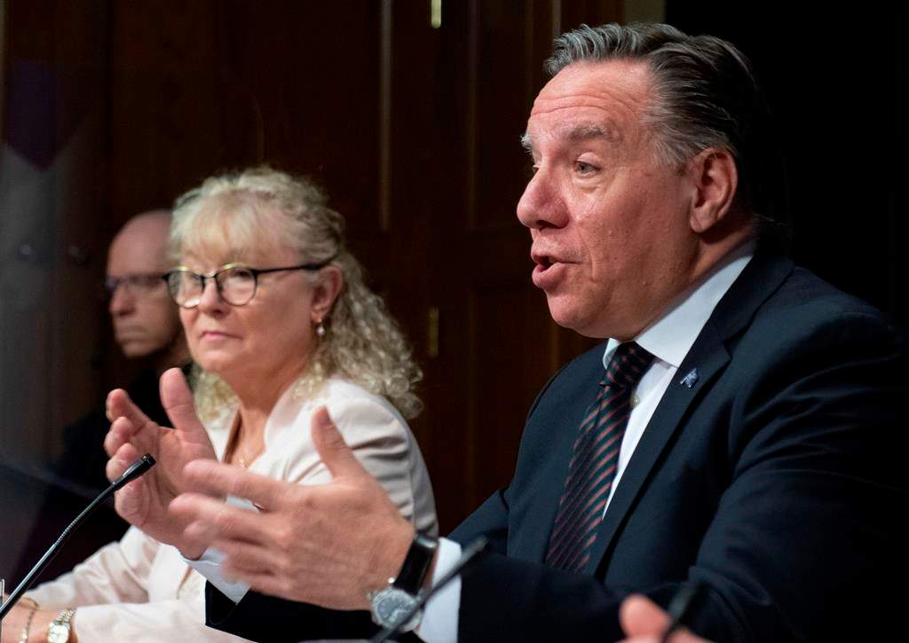 Quebec Premier Francois Legault speaks during a news conference on the COVID-19 pandemic, Tuesday, June 2, 2020 at the legislature in Quebec City. Quebec Minister Responsible for Seniors and Informal Caregivers Marguerite Blais, left, looks on.