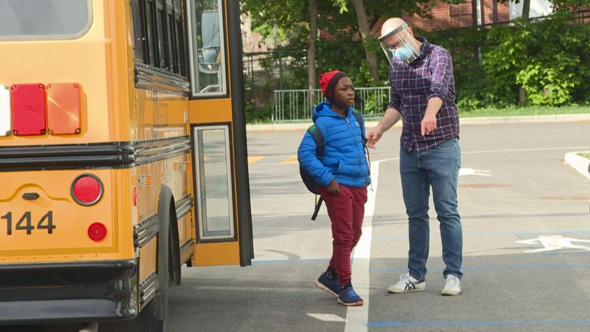 Mac Kay Centre School Vice-principal Greg Watson guides a student to a 2-metre line as the student arrives for the first day of classes, after the school closed because of COVID-19 pandemic. 