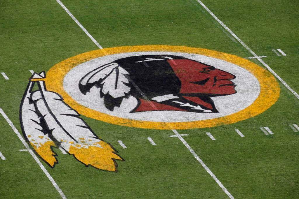FILE - In this Aug. 7, 2014 file photo, the Washington Redskins NFL football team logo is seen on the field before an NFL football preseason game against the New England Patriots in Landover, Md. The recent national conversation about racism has renewed calls for the Washington Redskins to change their name. D.C. mayor Muriel Bowser called the name an "obstacle" to the team building its stadium and headquarters in the District, but owner Dan Snyder over the years has shown no indications he'd consider it.