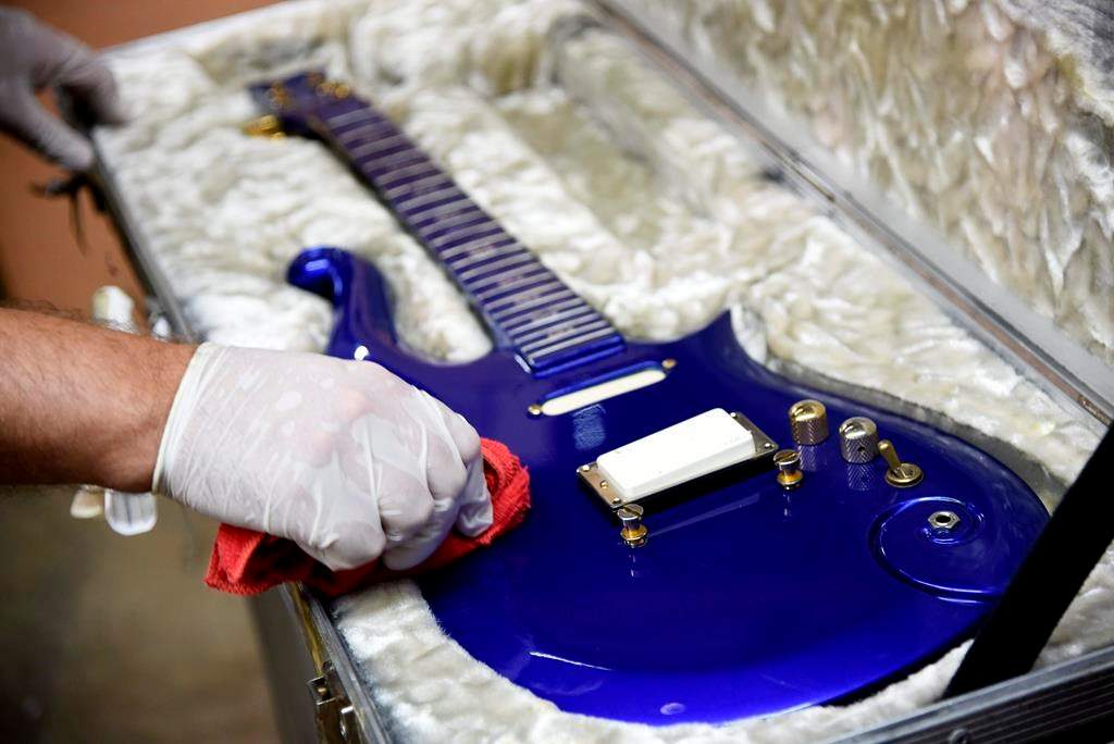 FILE - In this May 6, 2020 file photo, the “Blue Angel” Cloud 2 electric guitar custom-made for the musician Prince in the 1980s is polished at Julien's Auctions warehouse in Culver City, Calif. On Friday, June 19, 2020, the instrument shot past the top estimate of $200,000 it was expected to fetch at the Music Icons sale at the auction house. (AP Photo/Chris Pizzello).