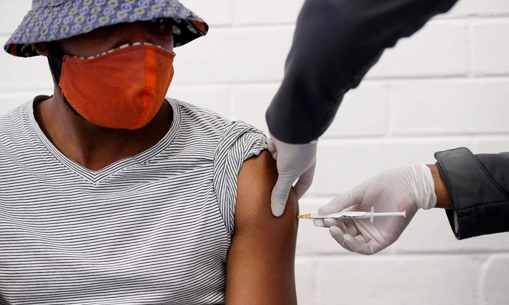 FILE - In this Wednesday, June 24, 2020 file photo, a volunteer receives a COVID-19 test vaccine injection. (AP Photo/Siphiwe Sibeko).