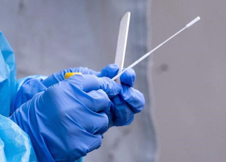 A nurse gets a swab ready at a temporary COVID-19 test clinic.