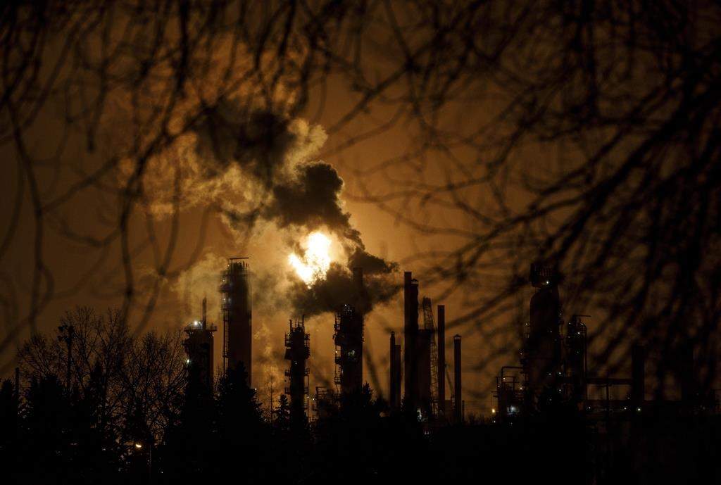 A flare stack lights the sky from the Imperial Oil refinery in Edmonton on Friday December 28, 2018. Seven environmental and Indigenous groups are asking the Alberta government to restart monitoring programs in the province's oilpatch as soon as possible. THE CANADIAN PRESS/Jason Franson.