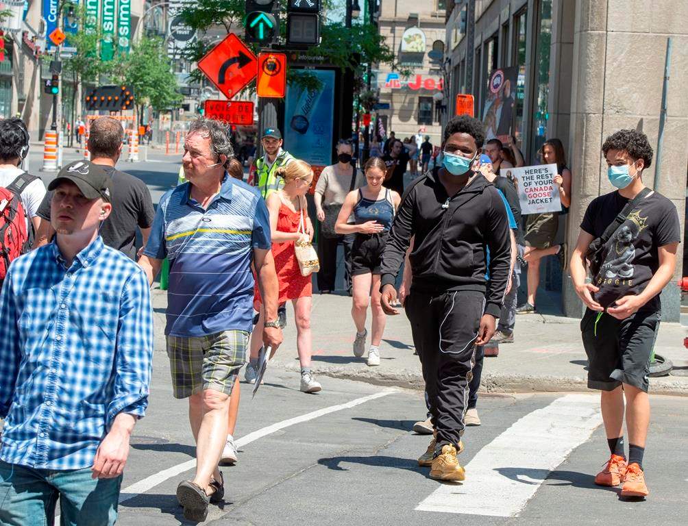 Pedestrians walk on Ste. Catherine street Thursday, June 18, 2020 in Montreal. Many Montrealers are still not wearing face masks as the government strongly recommends. THE CANADIAN PRESS/Ryan Remiorz.