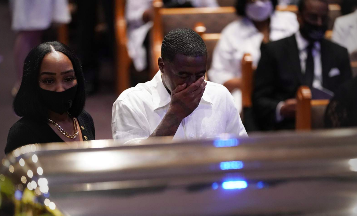 Mourners pause by the casket of George Floyd during a funeral service for Floyd at The Fountain of Praise church Tuesday, June 9, 2020, in Houston.