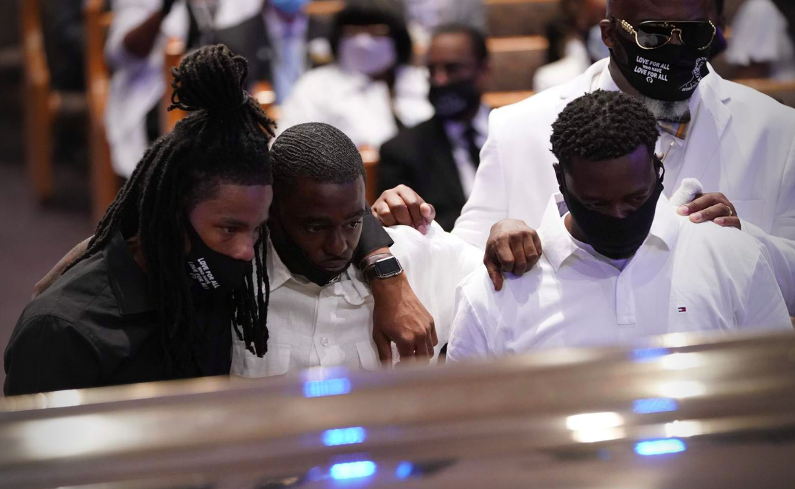 Mourners pause by the casket of George Floyd during a funeral service for Floyd at The Fountain of Praise church Tuesday, June 9, 2020, in Houston.
