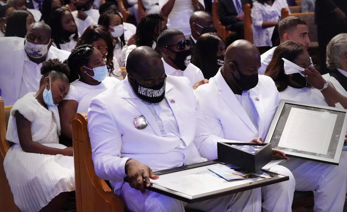 The family of George Floyd handles items given to them by Houston Mayor Sylvester Turner during the funeral service for George Floyd at The Fountain of Praise church Tuesday, June 9, 2020, in Houston.