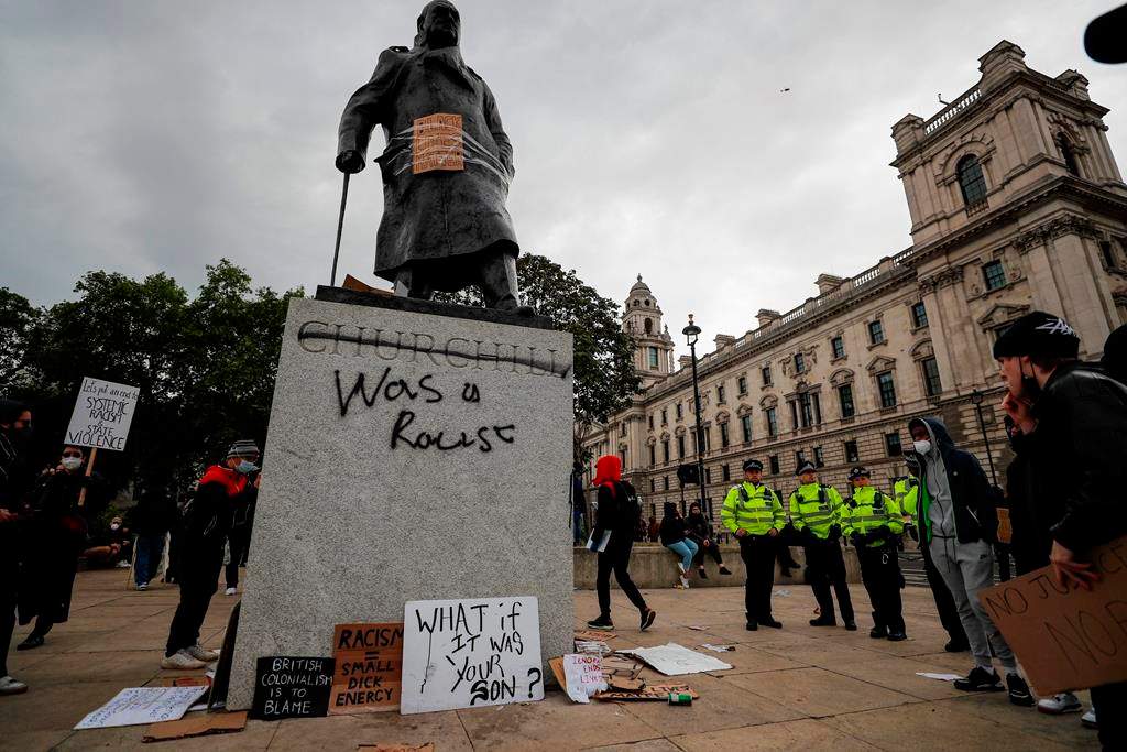 Protesters and police gather around Winston Churchill statue in Parliament Square during the Black Lives Matter protest rally in London, Sunday, June 7, 2020. (AP Photo/Frank Augstein)