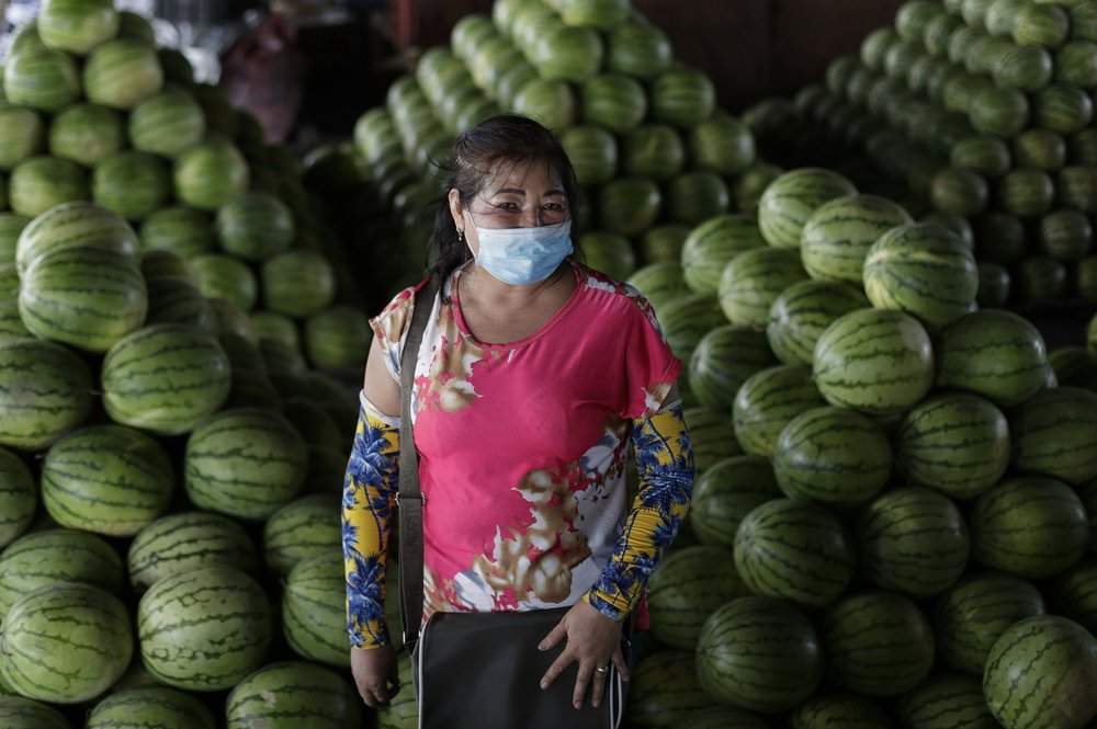 62-year-old fruit vendor Peda Tuazon poses at her stall in Manila, Philippines on Tuesday, July 21, 2020. Tuazon said she will convince the person to wear a mask to prevent the spread of COVID.