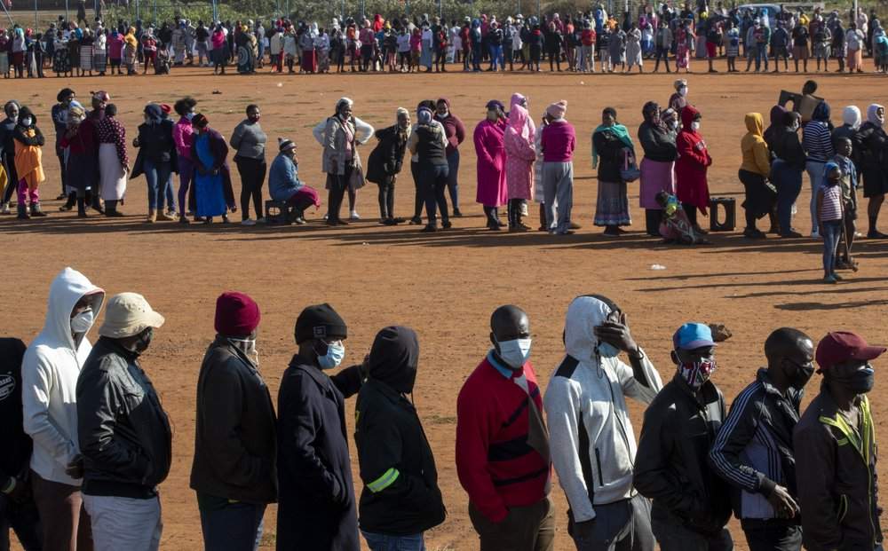 FILE — In this May 20, 2020 file photo, people affected by the coronavirus economic downturn line up to receive food parcels in Pretoria, South Africa, South Africa's economy is expected to decline by 7.2% this year, its worst performance in 90 years, as the coronavirus pandemic takes a toll on sub-Saharan Africa's most developed country. 