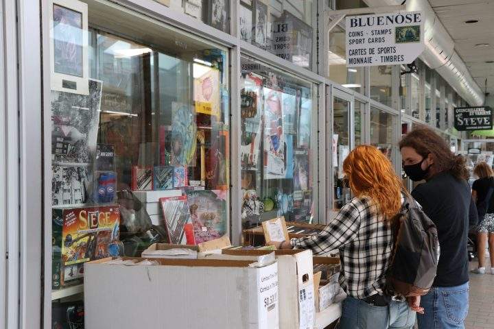 Plaza Pointe-Claire shoppers browse Bluenose Collectible’s storefront before entering on Tuesday, July 21, 2020. 